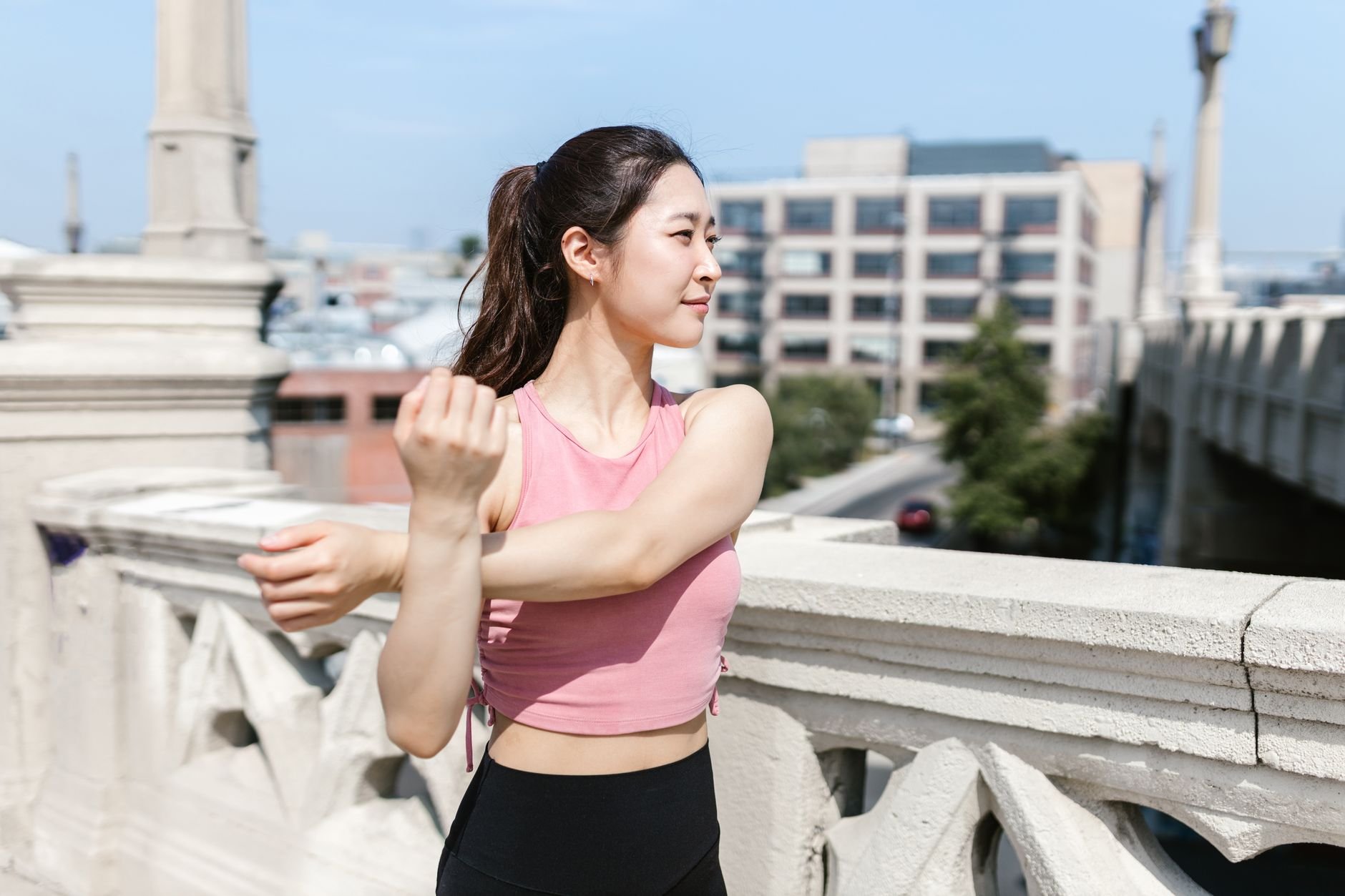 Young woman stretching outdoors in activewear for a healthy lifestyle.
